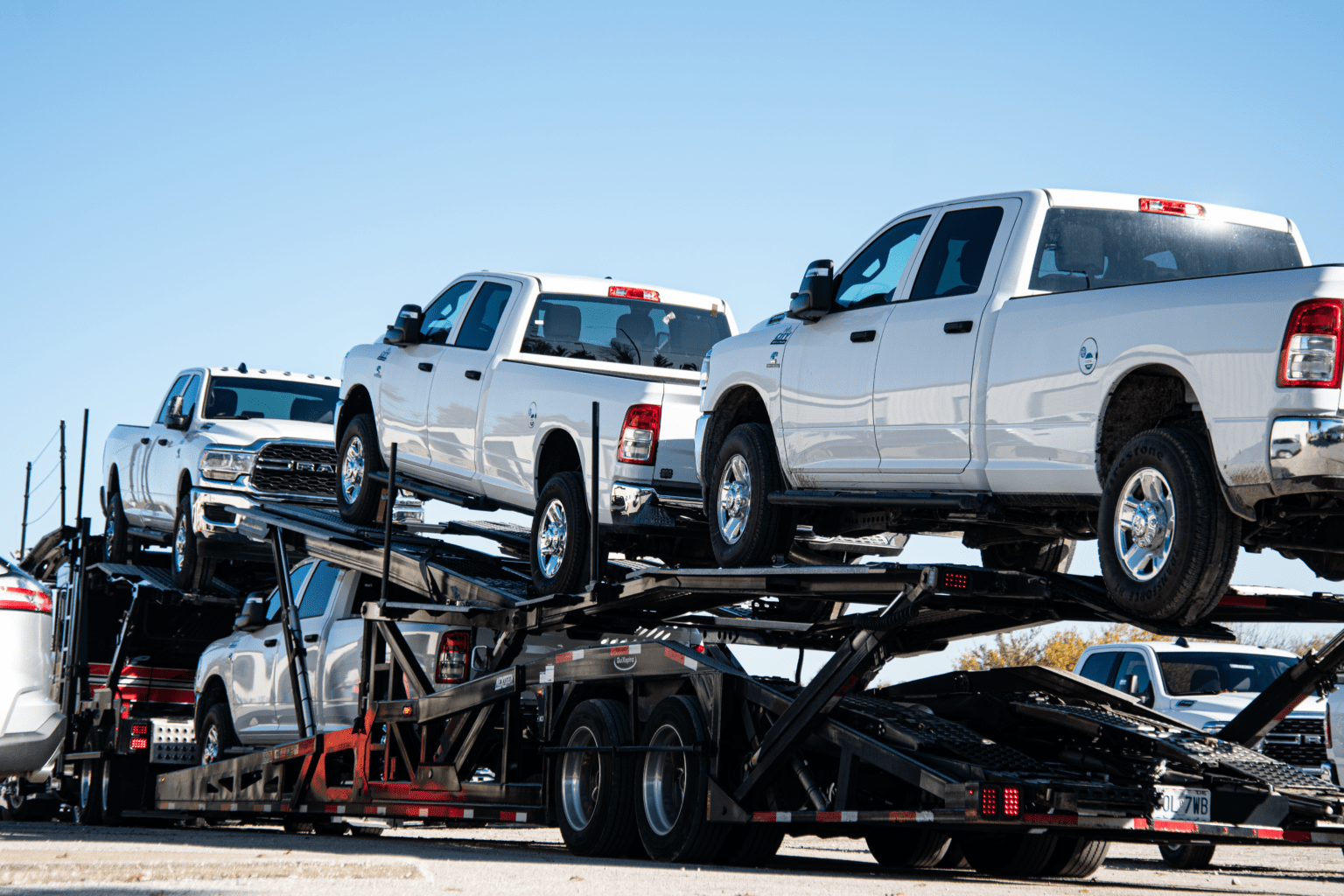 A car hauler truck loaded with City Rent a Truck commercial vehicles, showcasing the company’s capability for nationwide delivery services.