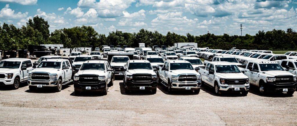 Aerial view of City Rent a Truck's lot, showcasing a diverse fleet of vocational-style rental vehicles, including dump trucks, flatbeds, pickup trucks, bucket trucks, and more.